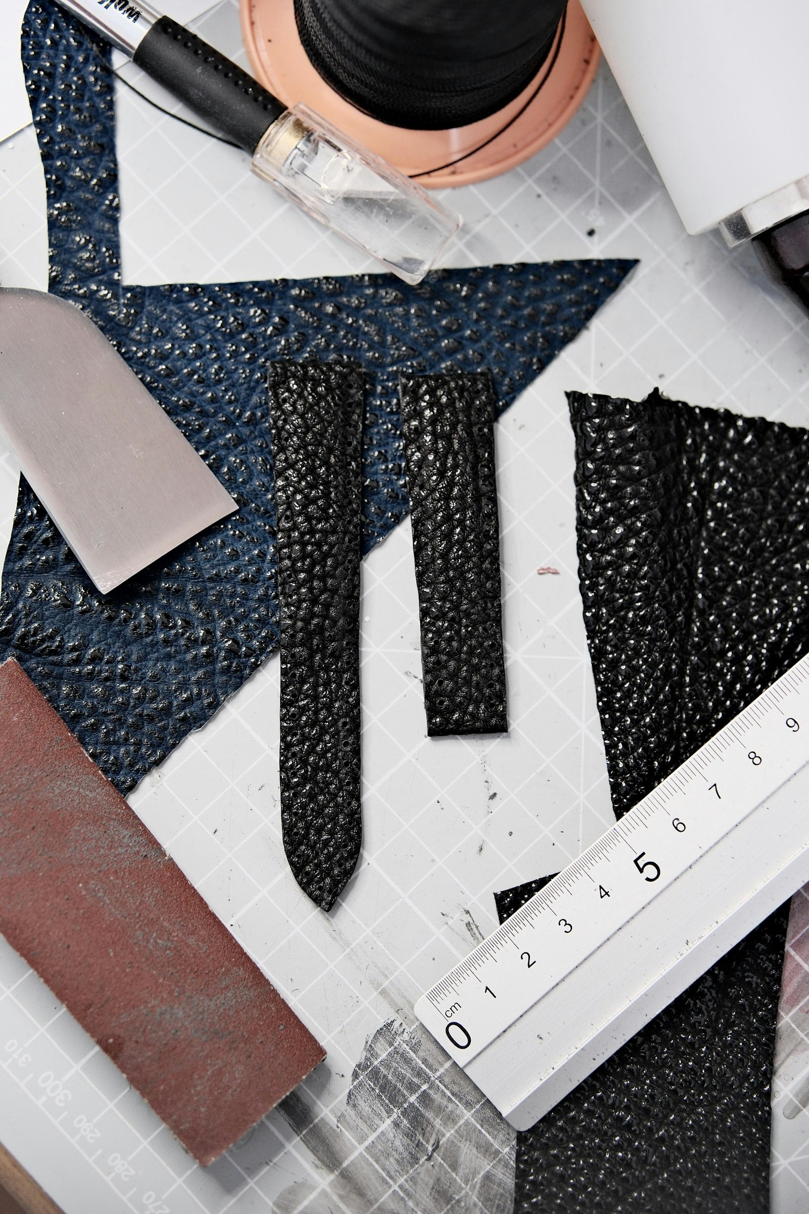 Leatherworking tools laid out on a cutting mat